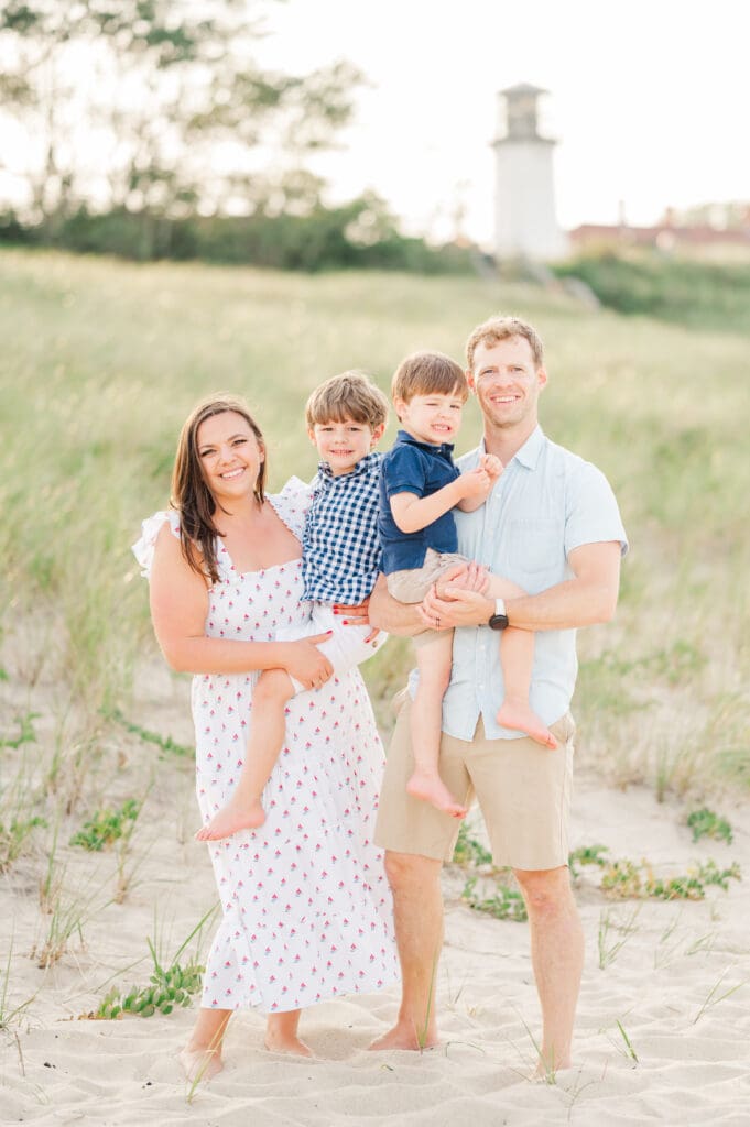 A family poses for a golden hour photo session on Lighthouse Beach in Chatham, MA